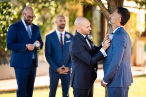 Lo sposo sistema la cravatta a un amico, preparativi con i testimoni