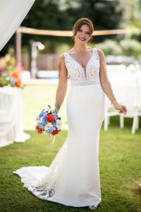 La sposa sorridente con il bouquet, ritratto a figura intera