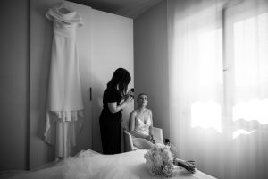 Il trucco della sposa con l'abito appeso, bianco e nero