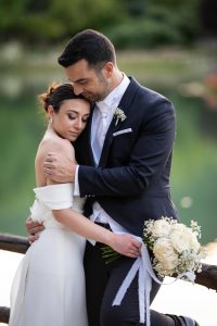 Abbraccio tenero degli sposi con il bouquet, matrimonio
