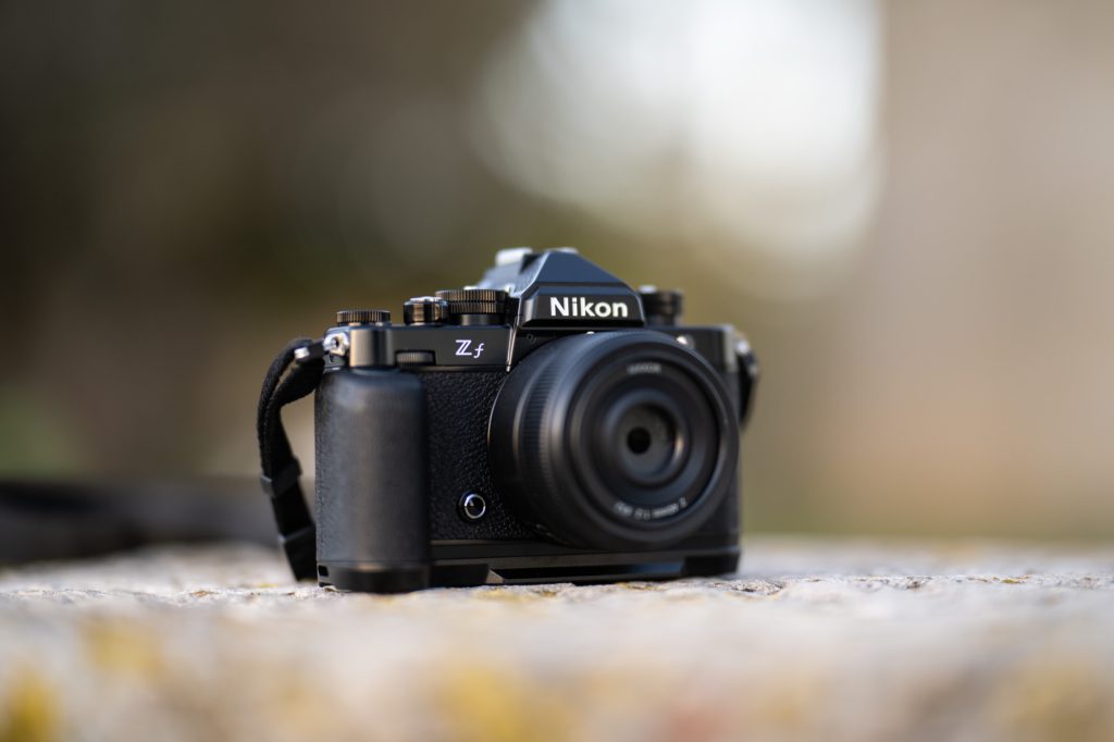 Black Nikon Zf with a pancake lens resting on a stone